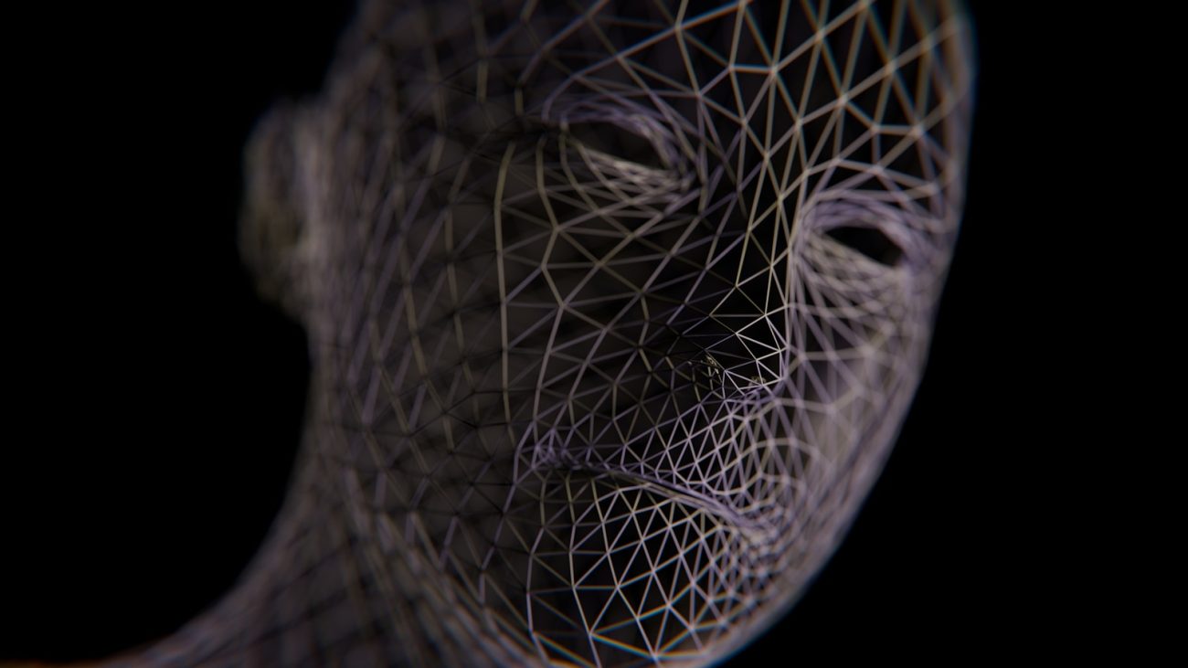 A wireframe head emerges from darkness.